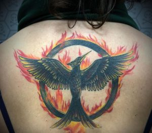 10 Outstanding Color Ink Hunger Games Mockingjay Bird Tattoo in Flaming Circle on Half Black