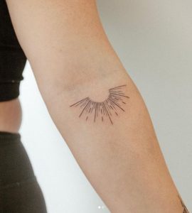 linework Sunburst Tattoo on the upper forearm