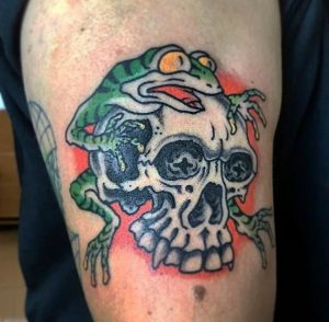 4 Incredible Color Ink Frog Sitting on Skull Tattoo Design on Arm