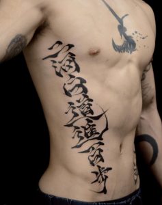 40 Fine Ink Kanji Tattoo Covering Rib to Belly