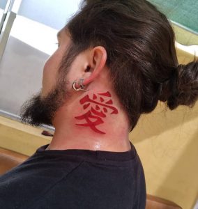 42 Red Ink Kanji Tattoo Behind the Ear