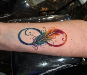 44 Lovely Feather With Raibow Color Tattoo on Front Arm