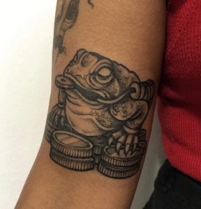 5 Black Ink Designed Traditional Frog Tattoo Design on Hand Bicep