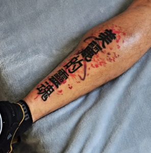62 Black and Red Ink Kanji Tattoo on Half Leg