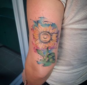 66 Flower Covered with Rainbow Color Tattoo Behind the Arm