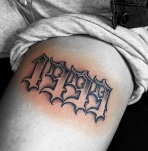 1999 lettering tattoo on the tricep