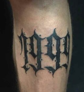 1999 lettering tattoo located on the forearm