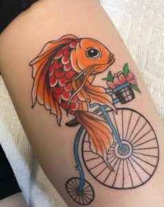 Colorful fish riding tattoo