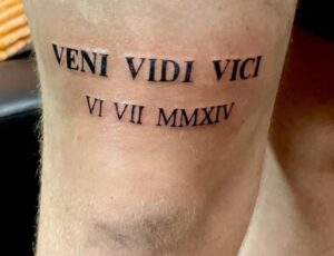 Roman Numeral Above Knee Tattoo